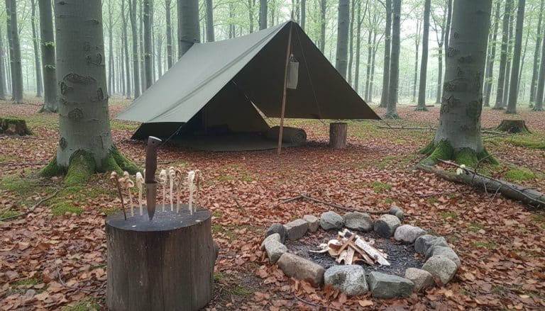 Bushcraft-lejr med tarp, fastbladet kniv og bålsted i dansk bøgeskov