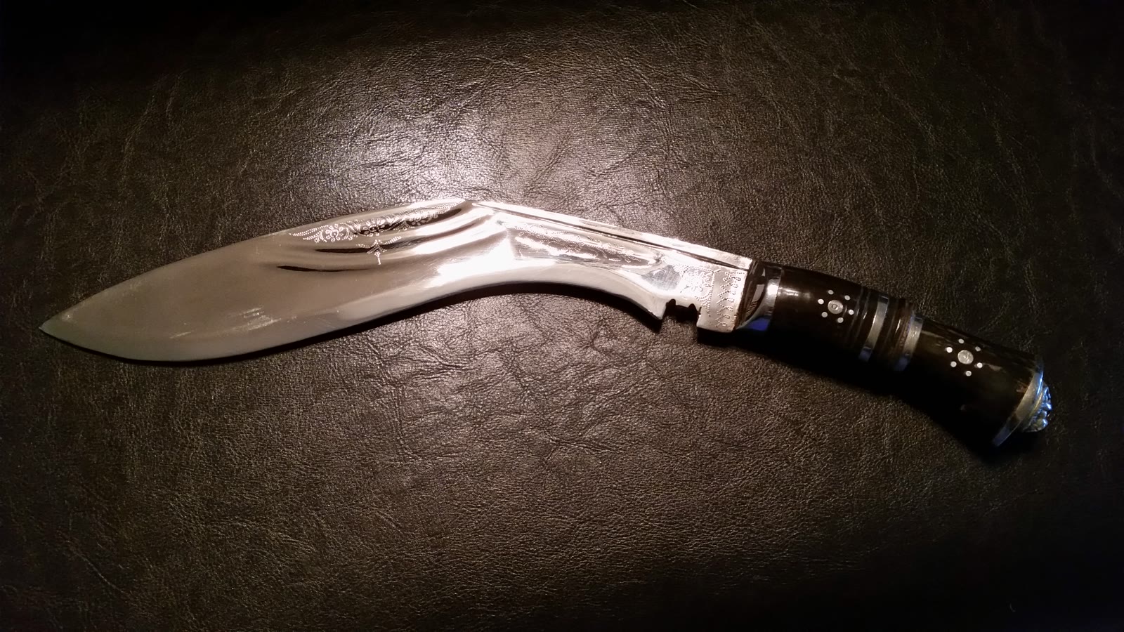 Traditionel nepalesisk kukri med forlæns bøjet blad og dekoreret horngreb